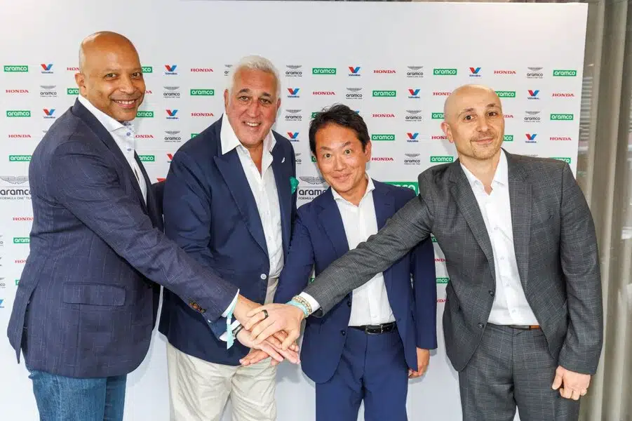 Мужчины представляют партнерство Aston Martin Honda Aramco Valvoline на встрече.