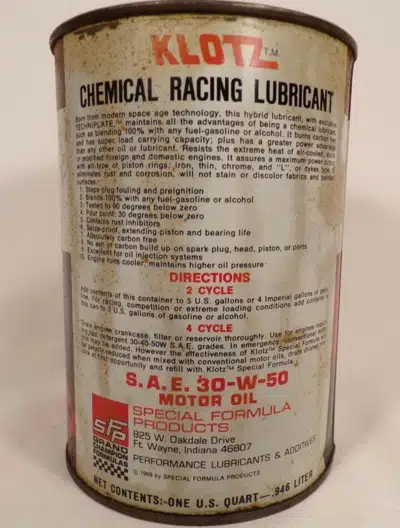 Винтажная банка моторного масла Klotz Chemical Racing Lubricant с инструкциями и составом, на фоне белой поверхности.