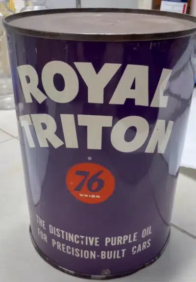 На фотографии изображена металлическая банка моторного масла Royal Triton 76 с фиолетовым фоном и белыми буквами.
