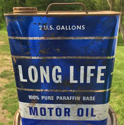 На фото старая синяя канистра с надписью Long Life Motor Oil для машинного масла.