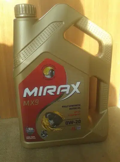 На фото канистра моторного масла Mirax MX9 0W-20 с логотипом и информацией о продукте на золотистой упаковке.
