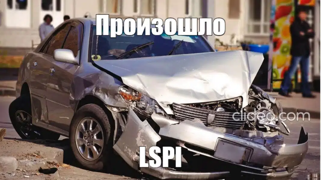 На фото разбитая серебристая машина с сильными повреждениями передней части, стоящая на обочине дороги.