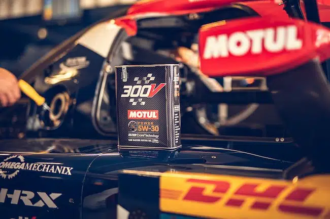Канистра масла Motul 300V на гоночном автомобиле в ремонтной мастерской во время технического обслуживания.