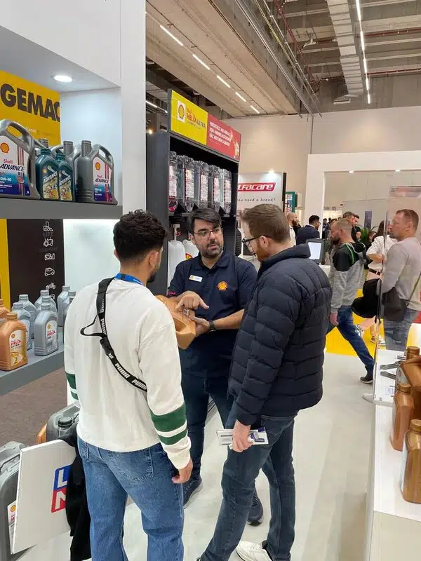 Посетители и консультант на стенде Shell обсуждают моторные масла