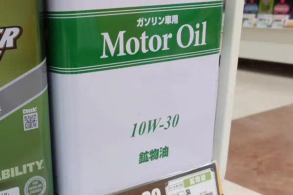 Канистра моторного масла 10W-30 с надписью Motor Oil и иероглифами в магазине.