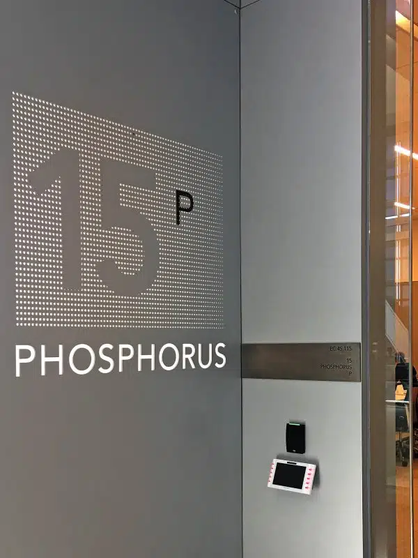 Табличка с номером 15 P и надписью PHOSPHORUS на серой стене здания.
