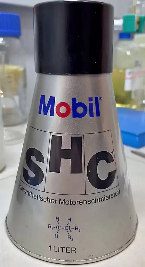 Серебристая банка моторного масла Mobil SHC, с химической формулой и надписью "1 Liter".