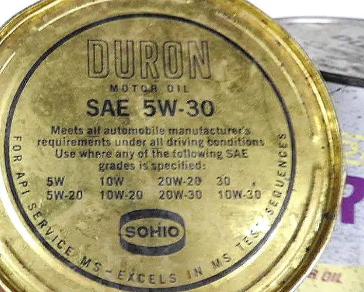 Крупный план золотистой банки моторного масла Duron SAE 5W 30 с указанием соответствия требованиям автопроизводителей и спецификаций SAE.