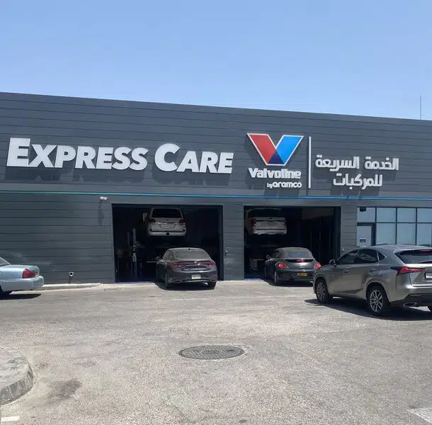 Фасад автосервиса Express Care с логотипом Valvoline и автомобилями на подъемниках внутри.